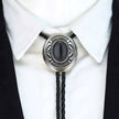 Western Cowboy Bolo Tie Necklace with black stone and silver metal on a white shirt.