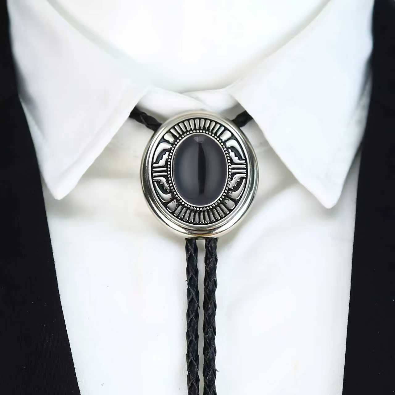 Western Cowboy Bolo Tie Necklace with black stone and silver metal on a white shirt.