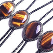 Four bolo ties with tiger eye stone and braided design on a white background