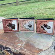 Three Buckhorn Cowhide Men's Wallets on a stone surface outdoors.