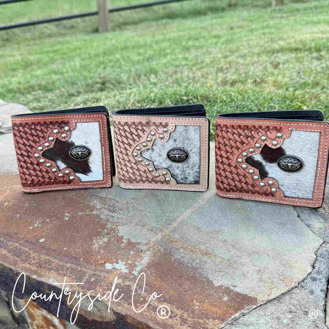 Three Buckhorn Cowhide Men's Wallets on a stone surface outdoors.