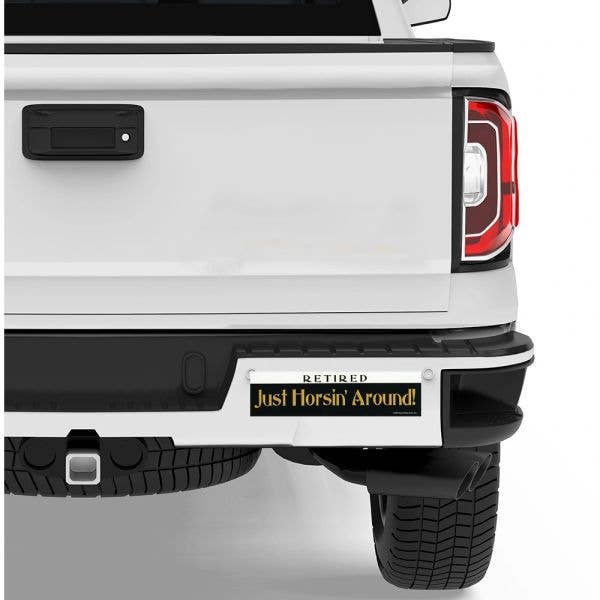 White truck with a humorous Bumper Sticker: Retired! Just Horsin' Around!