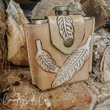 Desperado Tooled  Leather Flask with leaf designs on a rustic background, featuring the 'Countryside Co' brand.