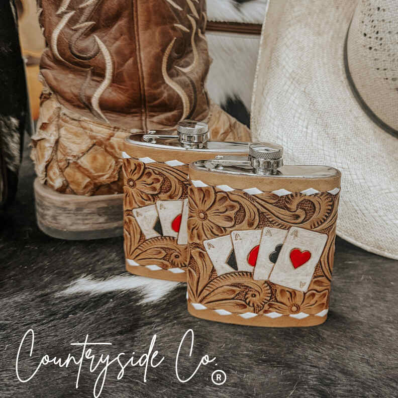 Handcrafted Leather Flask Stainless Steel with playing card design on a rustic surface, featuring 'Countryside Co' branding.
