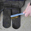 Person cleaning a horse boot with Cashel Hook and Loop Brush