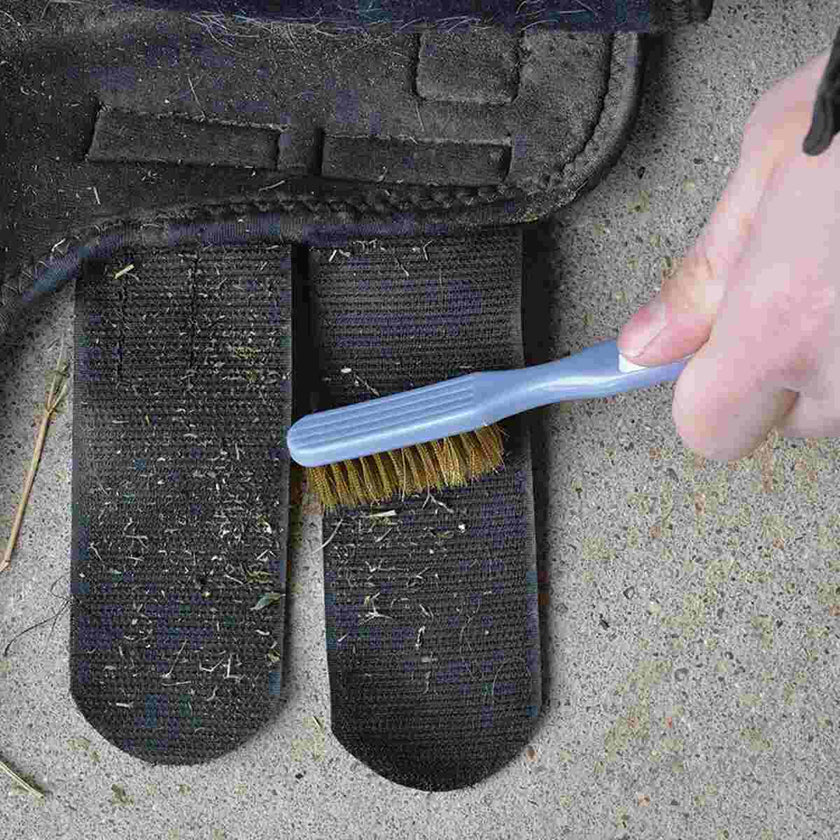 Person cleaning a horse boot with Cashel Hook and Loop Brush