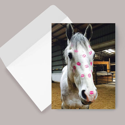 Horse Birthday Card: Horse Kiss Horse with pink kisses on a greeting card inside an open envelope.