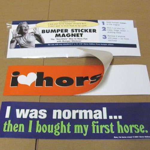 Three bumper stickers on a cardboard surface, including 'i ❤️ hors', 'I was normal as examples to use on the magnet