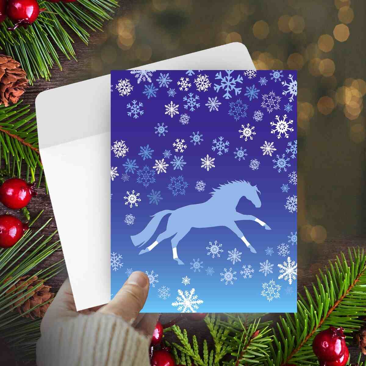 Horse Christmas Card - Galloping -with horse design on a blue background with snowflakes, surrounded by festive elements.
