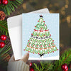 Horse Christmas Card - Horse Shoes - with a tree design held over a festive background with pine branches and berries.