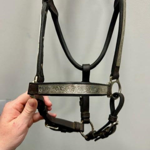 Hand holding a KHS-E Cob Showmanship Halter decorative metal trim against a gray background