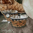 Decorative Leather Flask Stainless Steel with intricate designs on a stone surface, featuring the 'Countryside Co' brand.