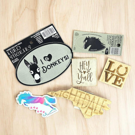 A collection of stickers and magnets on a wood background.