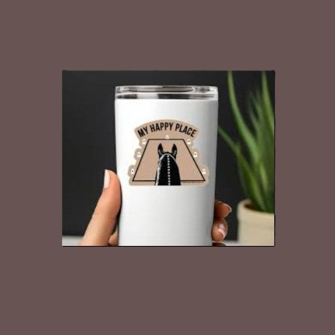 Tumbler with 'My Happy Place' design held by a hand, with a plant in the background.