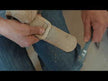 A person using a Cashel Hook and Loop Brush to clean dust and dirt from velcro on horse splint boots.