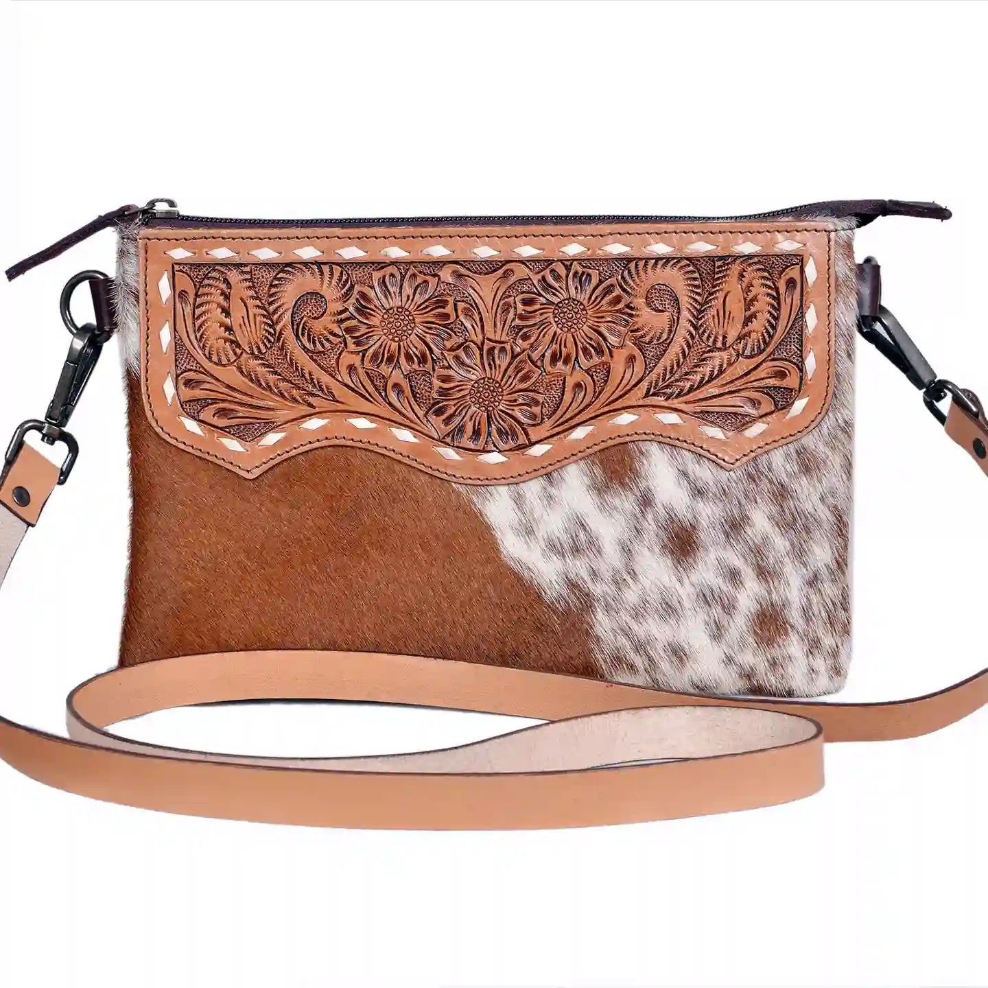 Brown cowhide crossbody bag with floral tooling and cowhide pattern on a white background